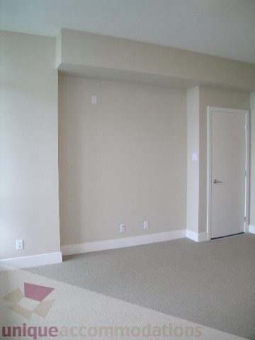 Spacious living room with beige walls and a modern fireplace. - 1903 - 1320 Chesterfield Street, North Vancouver