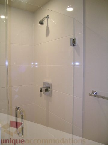 Modern bathroom with glass shower and sleek white tiles. - 1903 - 1320 Chesterfield Street, North Vancouver