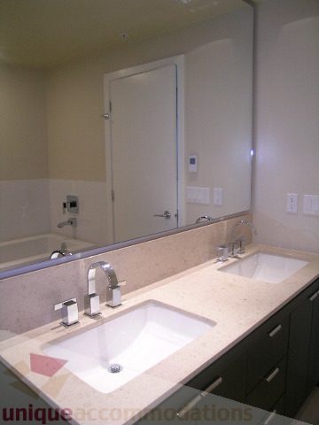 Bathroom with modern sink, large mirror, and beige countertop. - 1903 - 1320 Chesterfield Street, North Vancouver