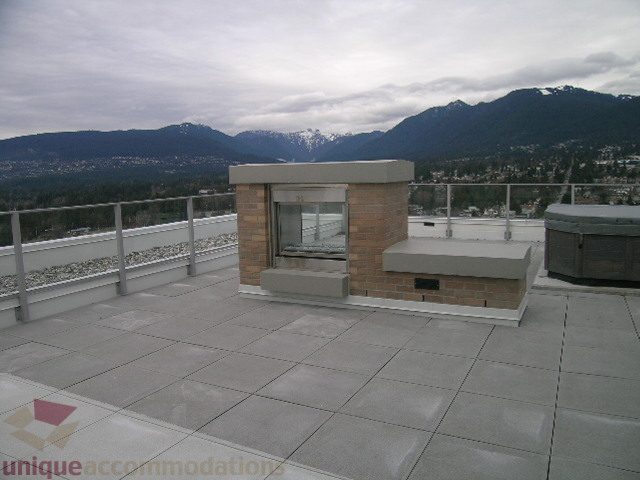 Spacious rooftop patio with a stunning city view and modern brick accents. - 1903 - 1320 Chesterfield Street, North Vancouver