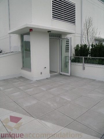 Spacious patio with modern glass doors and sleek tiled flooring. - 1903 - 1320 Chesterfield Street, North Vancouver