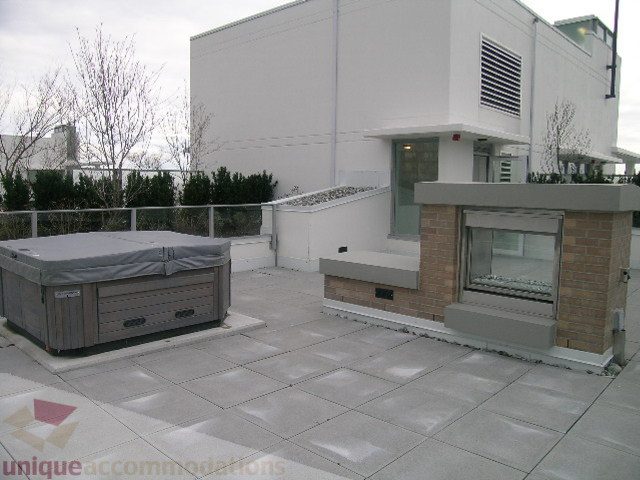 Spacious rooftop terrace with hot tub, brick accents, and modern furnishings. - 1903 - 1320 Chesterfield Street, North Vancouver
