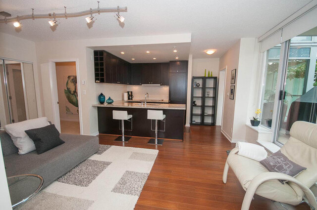 Open-concept living space with hardwood floors, modern kitchen, and cozy seating area. - 903 - 821 Cambie Street, Vancouver Downtown