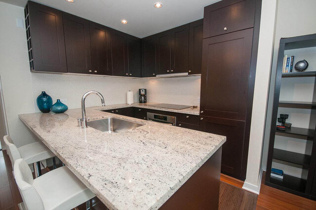 Bright kitchen with granite countertops, dark wood cabinets, and a modern sink setup. - 903 - 821 Cambie Street, Vancouver Downtown