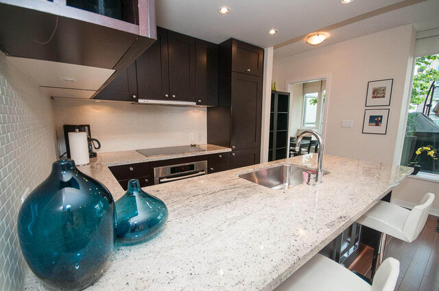 Bright kitchen with granite countertops, dark cabinets, and a modern sink setup. - 903 - 821 Cambie Street, Vancouver Downtown