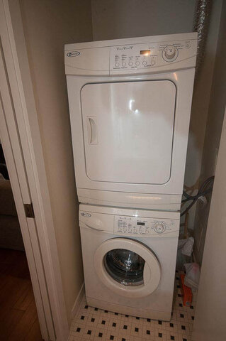 Bright laundry room with stacked washer and dryer, tiled floor, and natural light. - 903 - 821 Cambie Street, Vancouver Downtown