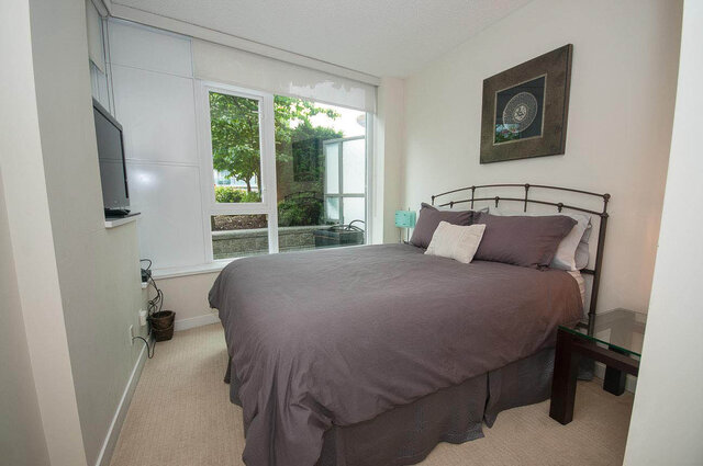 Spacious bedroom with a king-sized bed, large window, and modern decor. - 903 - 821 Cambie Street, Vancouver Downtown