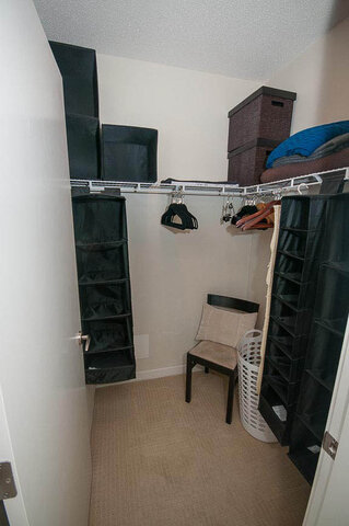 Furnished den with closet organizers, hanging hangers, and a small chair. - 903 - 821 Cambie Street, Vancouver Downtown