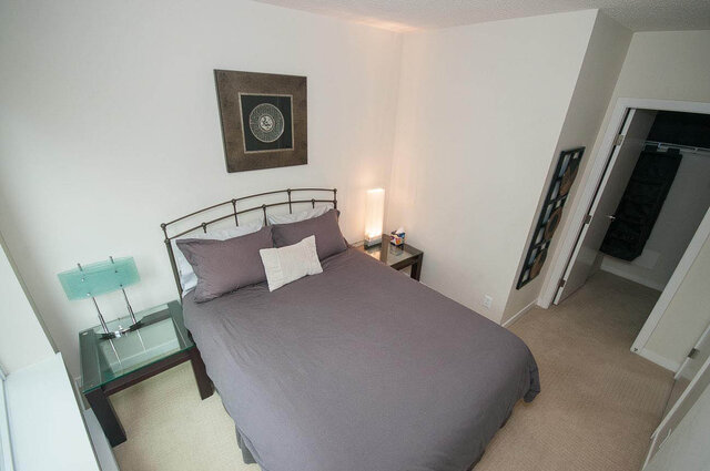 Spacious 1-bedroom + den with a cozy bed, glass nightstands, and a stylish wall art piece. - 903 - 821 Cambie Street, Vancouver Downtown