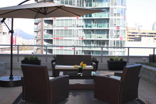Furnished rooftop patio with modern furniture, city views, and a large umbrella. - 903 - 821 Cambie Street, Vancouver Downtown