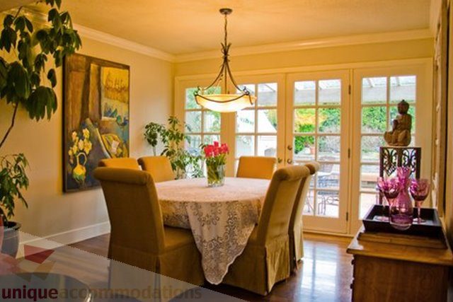 Spacious dining area with French doors leading to garden, elegant chandelier, and vibrant floral centerpiece. - 1330 Sinclair Street, West Vancouver