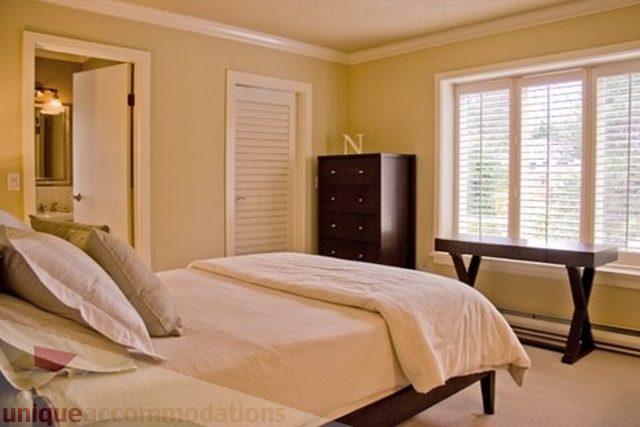 Spacious bedroom with large windows and modern furniture. - 1330 Sinclair Street, West Vancouver
