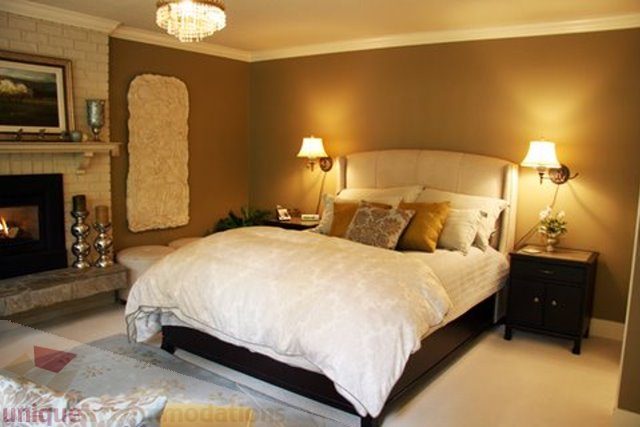 Cozy bedroom with a king-sized bed, soft lighting, and a fireplace. - 1330 Sinclair Street, West Vancouver