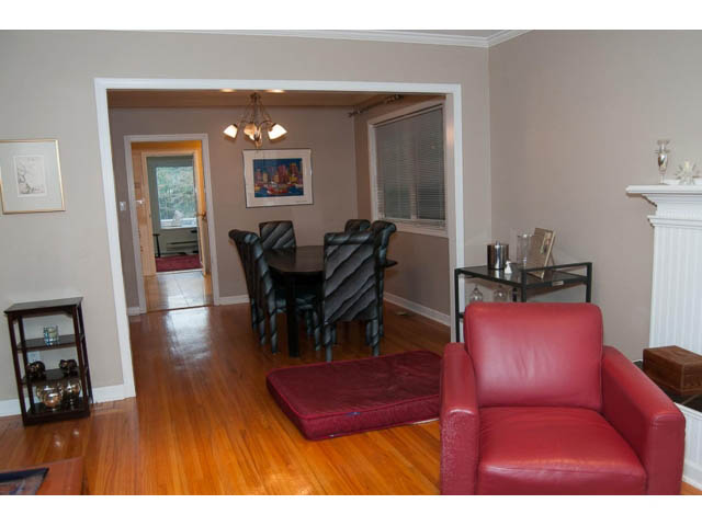 Spacious living room with red leather furniture and hardwood floors. - 5680 Marine Drive, West Vancouver