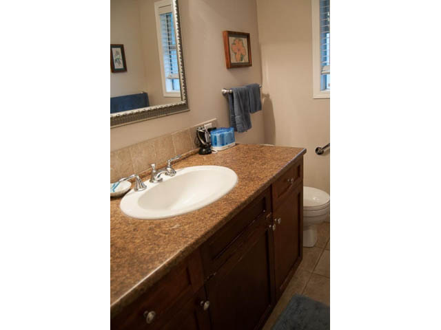 Furnished bathroom with granite countertops and wooden cabinets. - 5680 Marine Drive, West Vancouver