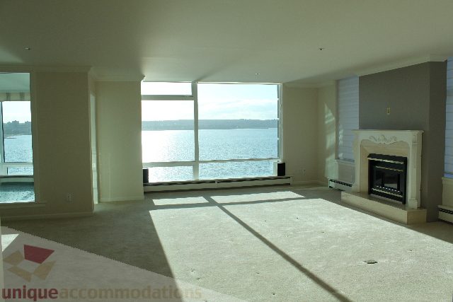 Spacious living room with large windows, city view, and fireplace. - 900 - 1919 Beach Ave, Vancouver Downtown