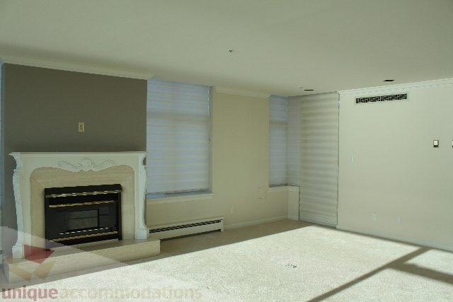 Bright living room with fireplace, neutral walls, and large windows. - 900 - 1919 Beach Ave, Vancouver Downtown