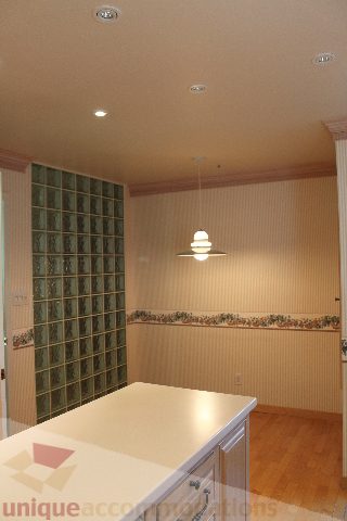 Bright kitchen with glass block wall, white countertops, and hardwood floors. - 900 - 1919 Beach Ave, Vancouver Downtown