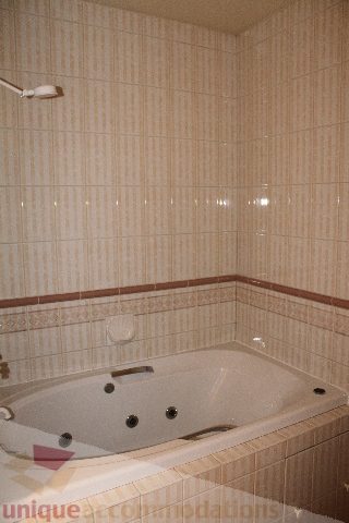 Bathroom with tiled walls, corner bathtub, and shower head. - 900 - 1919 Beach Ave, Vancouver Downtown