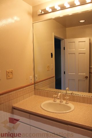 Bathroom with beige walls, light wood vanity, and a mirror above the sink. - 900 - 1919 Beach Ave, Vancouver Downtown