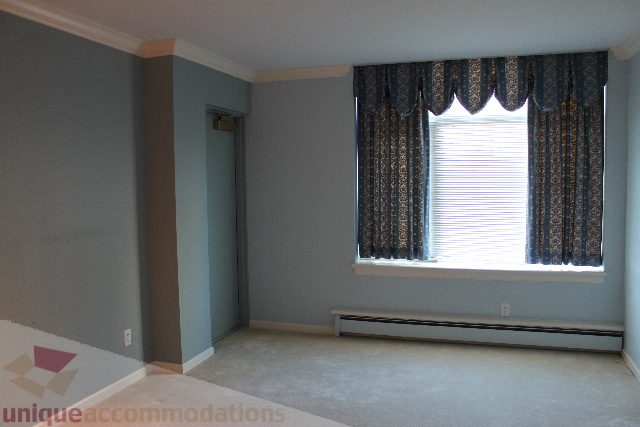 Bright living room with patterned curtains and carpeted floor. - 900 - 1919 Beach Ave, Vancouver Downtown