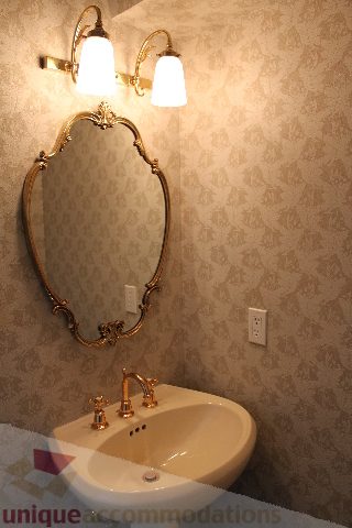 Bathroom with ornate mirror, gold fixtures, and patterned wallpaper. - 900 - 1919 Beach Ave, Vancouver Downtown