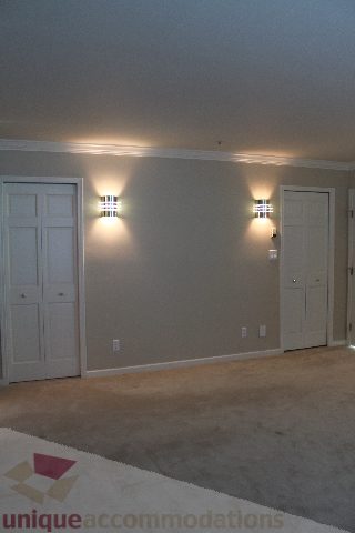 Furnished living room with beige walls, carpeted floor, and wall-mounted lights. - 900 - 1919 Beach Ave, Vancouver Downtown