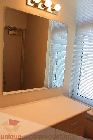 Bathroom with large mirror, light wood vanity, and window with blinds. - 900 - 1919 Beach Ave, Vancouver Downtown