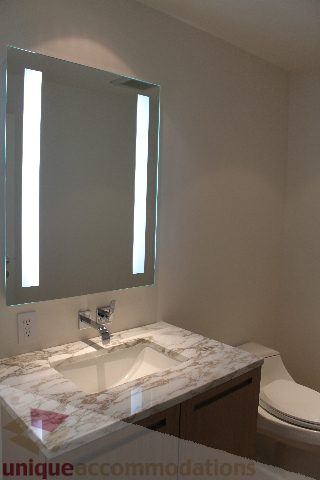 Bathroom with marble countertop and modern lighted mirror. - 2407 - 1011 West Cordova Street, Vancouver Downtown