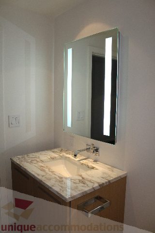 Bathroom with marble countertop and modern lighting fixture. - 2407 - 1011 West Cordova Street, Vancouver Downtown