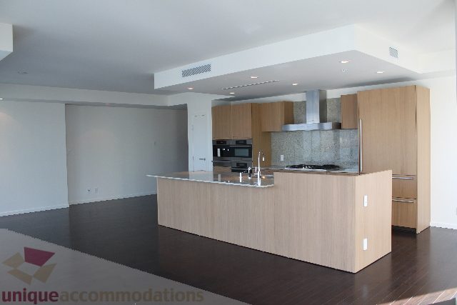 Bright kitchen with light wood cabinets, stainless steel appliances, and dark hardwood floors. - 2407 - 1011 West Cordova Street, Vancouver Downtown