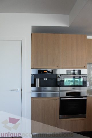 Bright kitchen with modern appliances and wooden cabinets. - 2407 - 1011 West Cordova Street, Vancouver Downtown