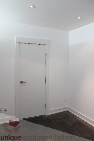 Spacious bedroom with a clean white door and carpeted floor, perfect for a cozy stay. - 301 - 650 Evergreen Place, North Vancouver