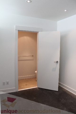 Spacious bathroom with white walls, open door, and modern fixtures. - 301 - 650 Evergreen Place, North Vancouver