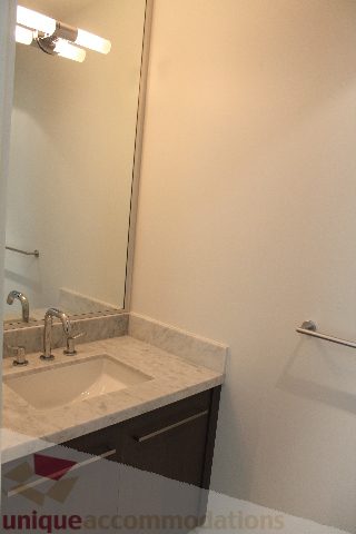 Modern bathroom with marble countertop and sleek faucet, perfect for a cozy 1-bedroom condo. - 301 - 650 Evergreen Place, North Vancouver