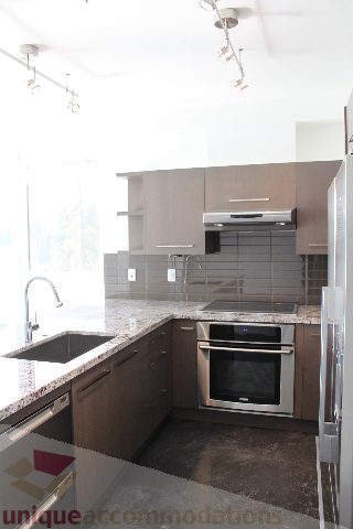 Modern kitchen with granite countertops and stainless steel appliances, offering a sleek and contemporary look.