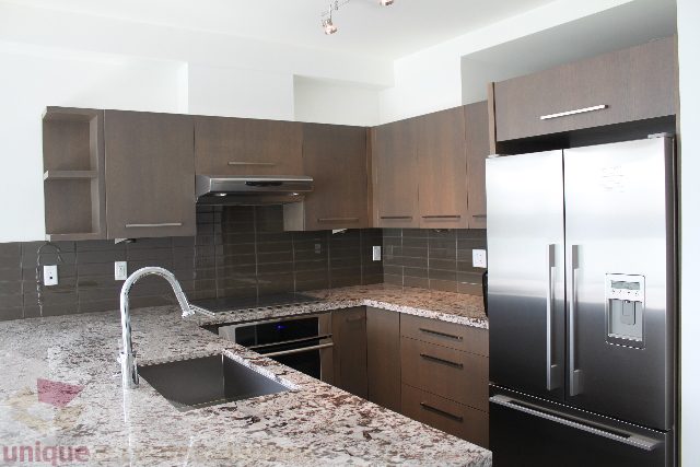 Modern kitchen with granite countertops and stainless steel appliances, perfect for a cozy 1-bedroom condo.