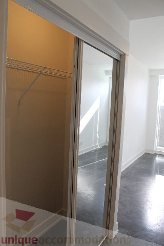 Spacious bedroom with sliding closet doors and hardwood floors. - 301 - 650 Evergreen Place, North Vancouver