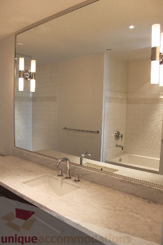 Spacious bathroom with marble countertops and a large mirror. - 301 - 650 Evergreen Place, North Vancouver
