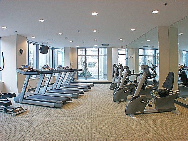 Fitness room with treadmills and exercise equipment, large windows offering city views. - 3705 - 689 Abbott Street, Vancouver Downtown