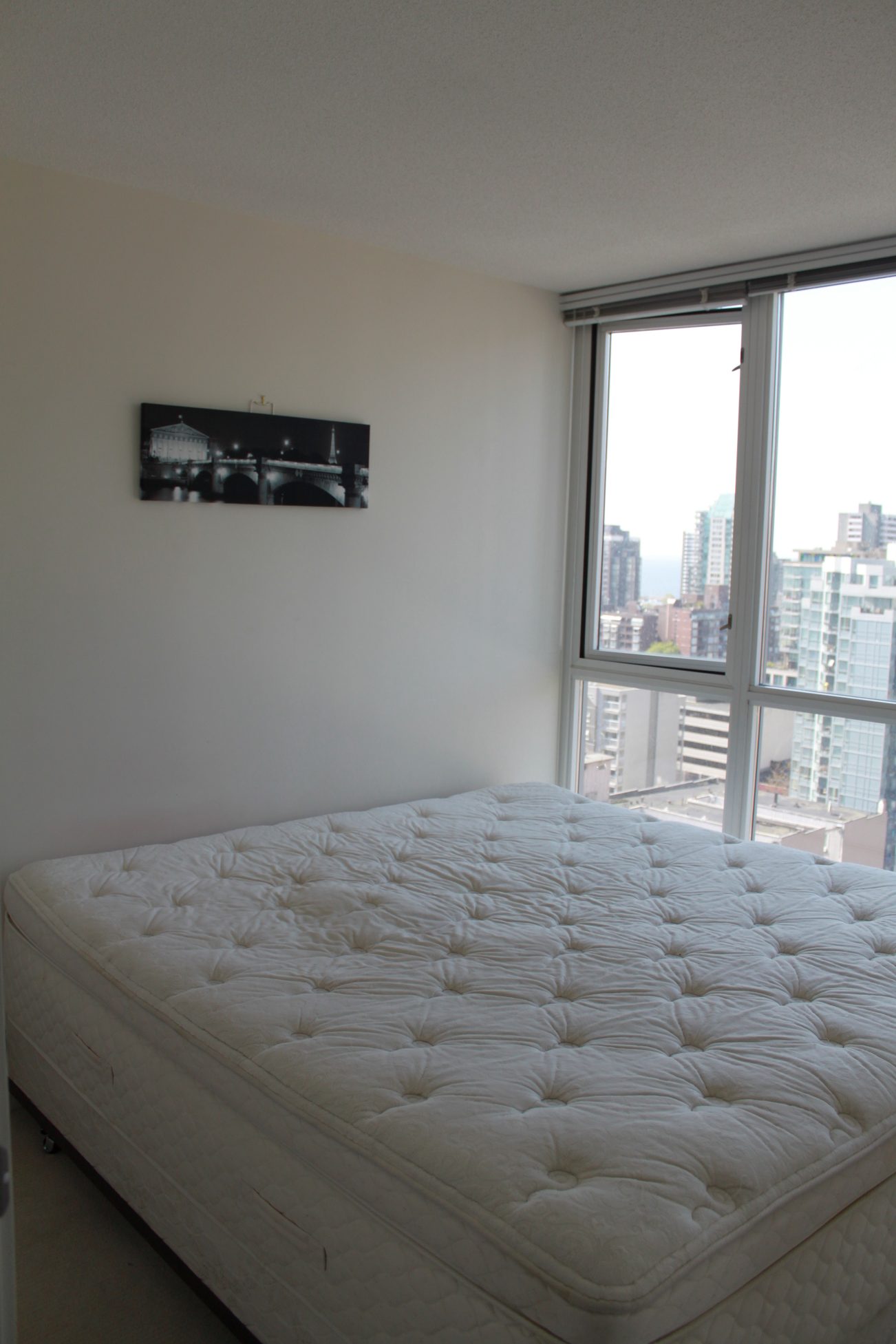 Bright bedroom with city view and tufted mattress. - 2001 - 1199 Seymour, Vancouver Downtown