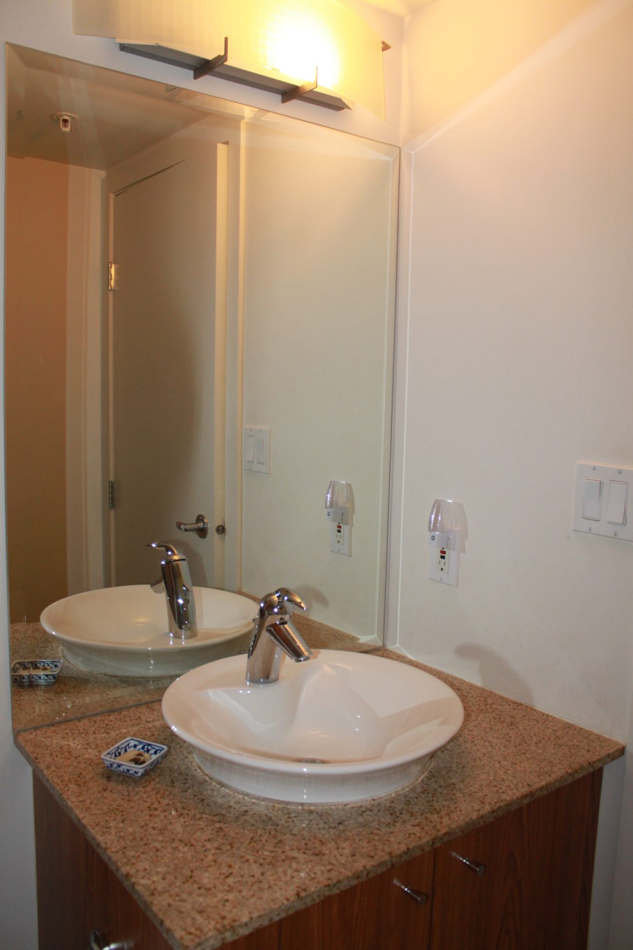 Bright bathroom with dual sinks, granite countertop, and modern lighting. - 2001 - 1199 Seymour, Vancouver Downtown