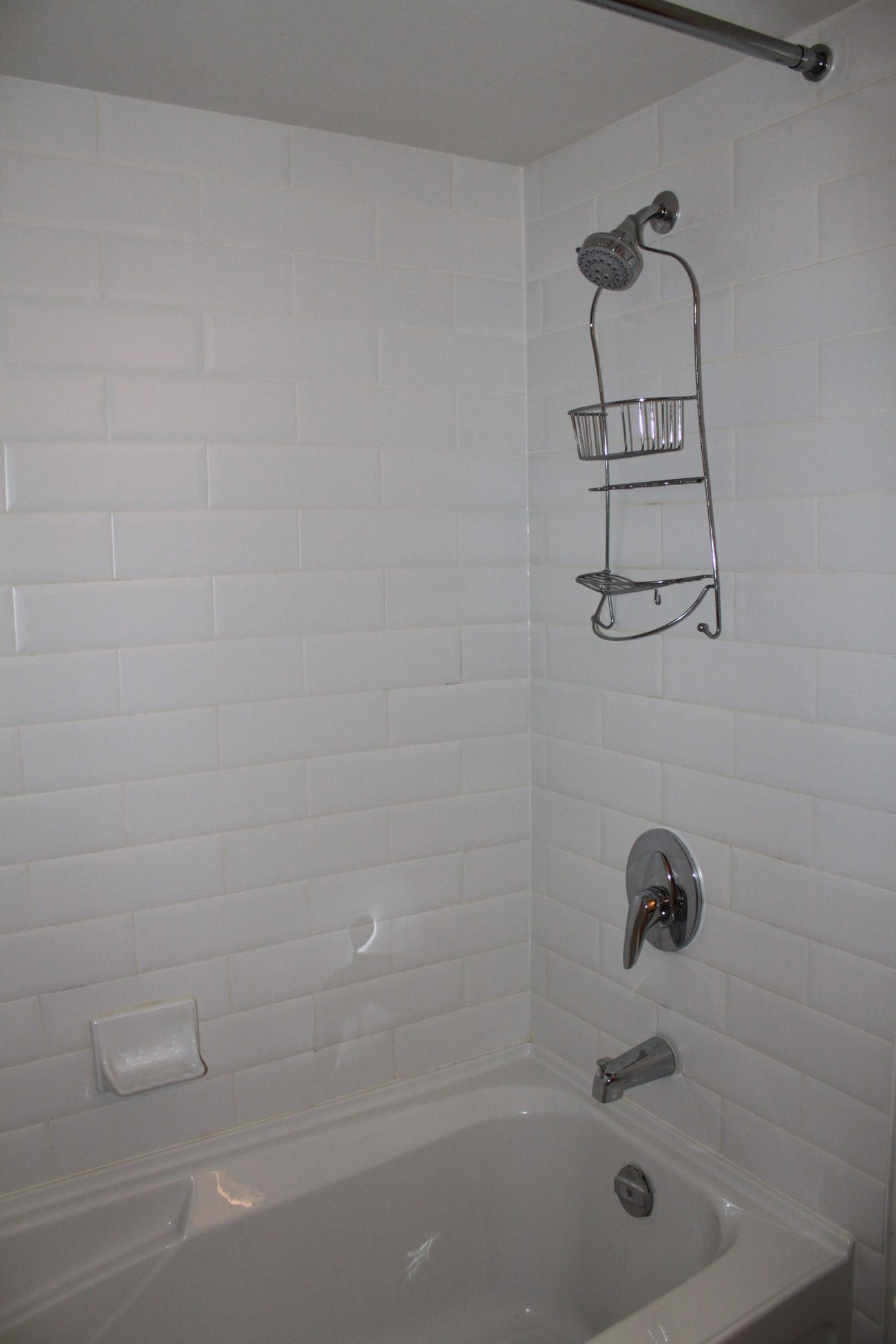 Bathroom with white subway tile, bathtub, and shower caddy. - 2001 - 1199 Seymour, Vancouver Downtown