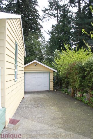 Furnished 2-bedroom + den house with a cozy driveway and lush greenery. - 2156 Cortell Ave, North Vancouver
