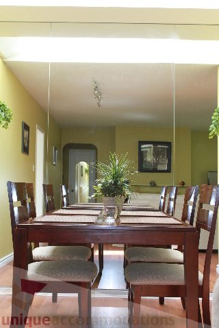 Dining room with wooden table, chairs, and potted plant. - 2156 Cortell Ave, North Vancouver