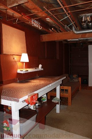 Den with exposed ceiling beams, rustic wood table, and lamp. - 2156 Cortell Ave, North Vancouver
