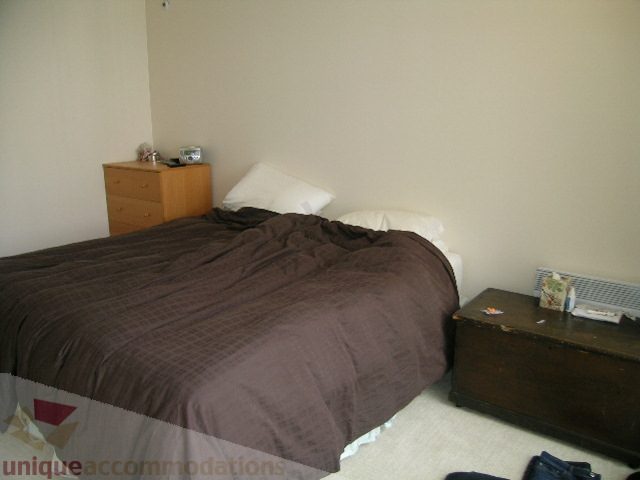 Furnished bedroom with brown bedding and wooden dresser. - 2507 - 950 Cambie Street, Vancouver Downtown