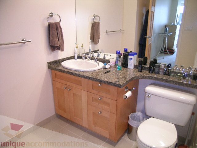 Furnished bathroom with granite countertops, wooden cabinets, and a toilet. - 2507 - 950 Cambie Street, Vancouver Downtown