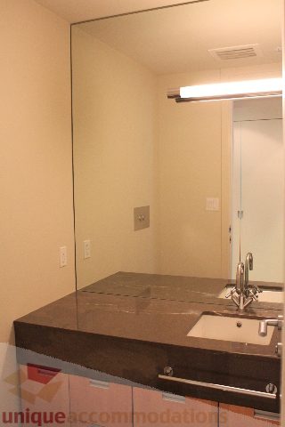 Modern bathroom with sleek countertop and large mirror. - 2205 - 1077 West Cordova, Vancouver Downtown