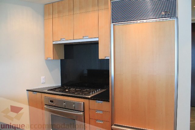 Bright kitchen with modern cabinetry and black countertops, perfect for a cozy downtown condo. - 2205 - 1077 West Cordova, Vancouver Downtown